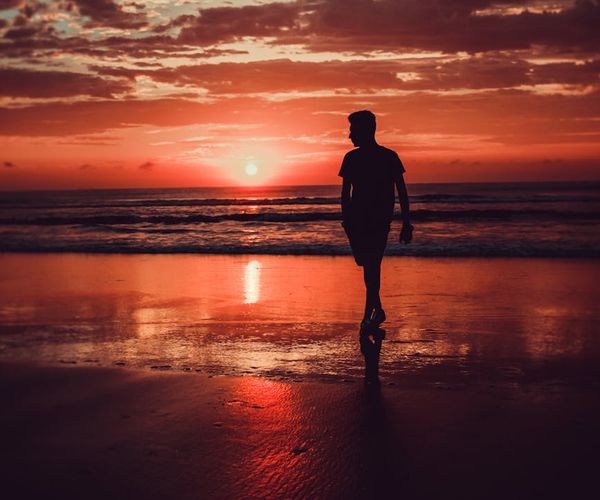 Silhouette of a person meditating during a beautiful sunrise.